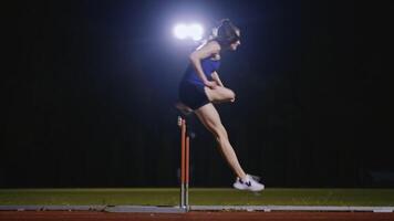 Female Athlete is Running Towards an Obstacle, Hurdling, Jumping Over the Barrier at High Speed while Sprinting in a Race. Cinematic Super Slow Motion video