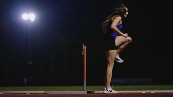 Female Athlete is Running Towards an Obstacle, Hurdling, Jumping Over the Barrier at High Speed while Sprinting in a Race. Cinematic Super Slow Motion video