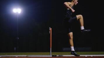 Male Athlete is Running Towards an Obstacle, Hurdling, Jumping Over the Barrier at High Speed while Sprinting in a Race. Cinematic Super Slow Motion video