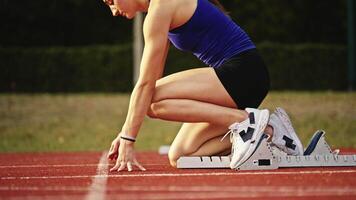 Female Runner on Athletics sprint race starting blocks on a dark background video