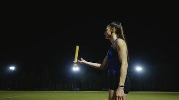 Female Athlete is playing with a relay race baton on the athletics race track after a successful competition race video