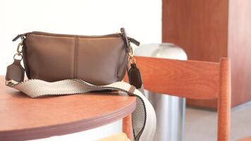 A stylish brown bag is elegantly placed on a table within a chic and modern cafe setting video