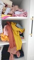 Messy closet with piled clothes and colorful accessories, displaying chaos and disorder in storage video