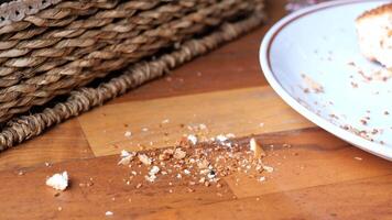 There are crumbs scattered on the kitchen table following a snack that was recently enjoyed video
