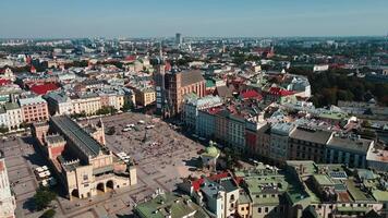 Aerial view of Krakow main market square with historic Cloth Hall , Sukiennice surrounding colorful buildings on sunny day. Cityscape of Krakow in Poland with tourists walking in old town video