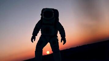 An animation of an astronaut standing silhouetted against a beautiful sunset on a distant planet, symbolizing the vastness of space and man's desire to explore. video