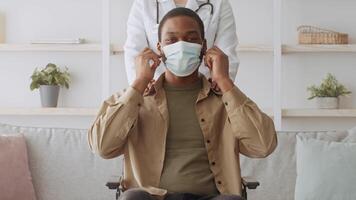 A patient sits calmly in a wheelchair while a healthcare professional stands behind, offering support during a check-up. The environment is bright and welcoming, promoting comfort and care. video