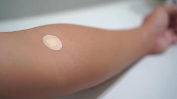 A medical adhesive bandage is placed on the injection site after blood sample collection to prevent bleeding and maintain cleanliness. video