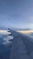 4k real Tempo cenas do avião voar olhando Fora a partir de avião janela. vertical cenas Visão a partir de a janela com prata asa do a avião. video