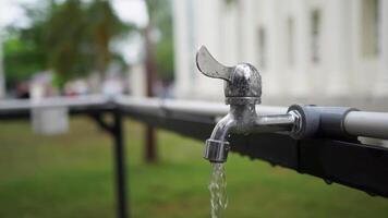 Close up of water flowing from the metal faucet. Water flows from the tap with blurred background video