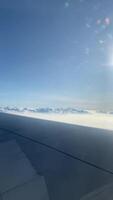 4k real Tempo cenas do avião voar olhando Fora a partir de avião janela. vertical cenas Visão a partir de a janela com prata asa do a avião. video