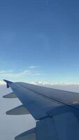 4k real Tempo cenas do avião voar olhando Fora a partir de avião janela. vertical cenas Visão a partir de a janela com prata asa do a avião. video