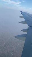 4k real Tempo cenas do avião voar olhando Fora a partir de avião janela. vertical cenas Visão a partir de a janela com prata asa do a avião. video