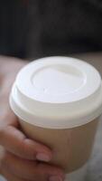 A CloseUp Image of a Disposable Coffee Cup Thoughtfully Held by a Hand in a Casual Setting video
