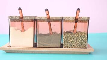 Elegant spice containers with beautiful copper handles on a colorful background video