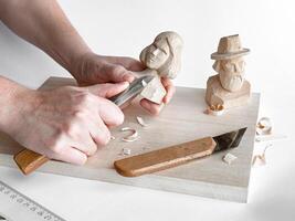 Wood carving art. Hands sculpting intricate figures on wooden board photo