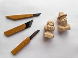 Artisan wood carving tools and handcrafted wooden sculptures on display photo