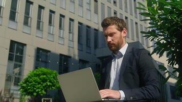 Concentrated Caucasian man business employer manager worker businessman male guy working online remote distant typing laptop computer pc internet consulting client chatting in city downtown web sales video