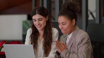 africano americano caucasiano fêmea escritório colegas de trabalho feliz alegre meninas senhoras o negócio parceiros mulheres de negócios alegrar ganhar conectados computador apostando computador portátil tela multirracial mulheres comemoro Alto cinco video