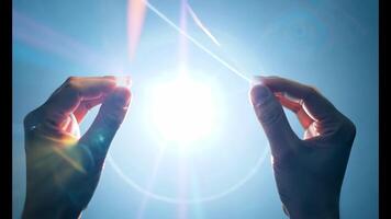 Hands delicately holding a glowing orb of light against a soft blue background, symbolizing energy, creation, and the power of human connection to the universe video