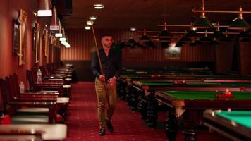 A man standing in front of a pool table video