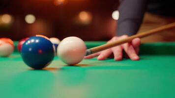 A person is holding a cue stick and playing a game of pool video