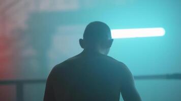 A man is standing in front of a light video