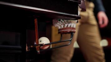 A person standing next to a pool table with a ball video