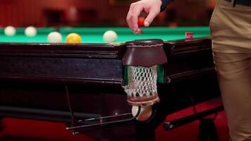 A man is holding a snooker ball on a snooker table video