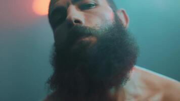 A man with a beard and a red light behind him video