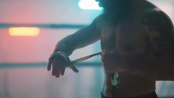 A man with a beard and tattoos is standing in front of a mirror video