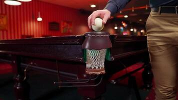 A man is holding a ball on a pool table video