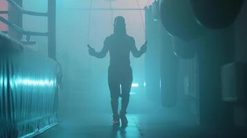 A man is walking through a foggy room with a rope video