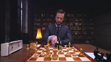 A man in a suit is playing chess on a table video