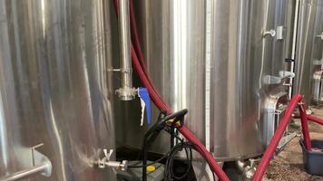 Close up red wine pouring to container for testing wine by giant cylinders. Wine produce processing steps, quality and industry business concept. video