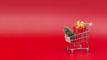 New Year concept stop motion animation of Shopping trolley with Christmas tree and gifts. copy apace video