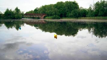 Toy boat of paper in the water. View of paper boat floating in the water video