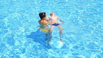 Boy and mother in swimming pool. Family having fun in swimming pool video