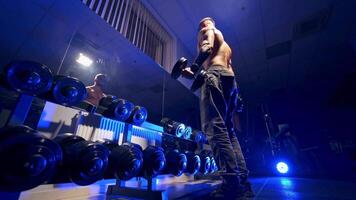 Fitness man with dumbbell in gym. Muscular bodybuilder guy doing exercises with dumbbells video