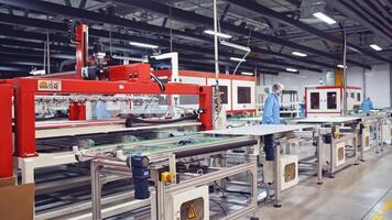Automated factory interior. Automated robotic arms assembling innovative product solar panels video