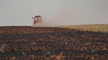 Tractor ploughing a field. Scale farming with tractor and plow in field video