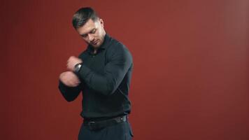Handsome man with strong body in a dark shirt preparing and having look at the camera. Half waist view . video