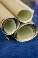 three small rolls of wallpaper on blue background . High quality photo