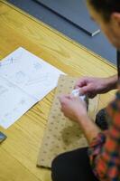 Man Assembling Furniture with Instruction Manual on Wooden Floor. High quality photo