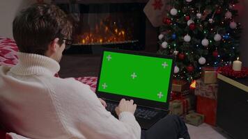 Man working from home on laptop, green screen chroma key in Christmas atmosphere. video