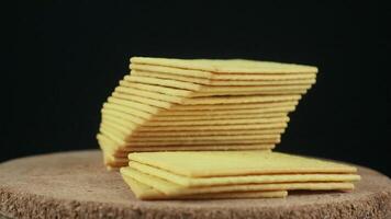 Stack of crispy salted crackers on black background. Rotating display video