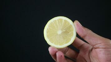 A man holds halves of a cut lemon in his hands. Exotic fruits in hands. Lemon close up video