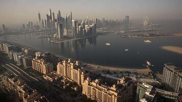 A showcasing a large body of water encircled by towering city structures during a vibrant Dubai sunset from Palm Jumeirah observation point video
