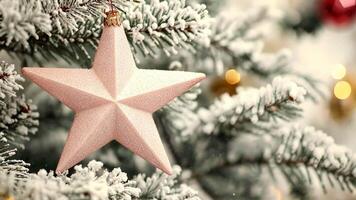 Sparkling star ornament on snow-dusted pine tree branch with golden lights, celebrating the joy of merry christmas and happy new year video