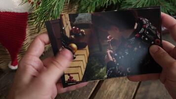 Hands browse through printed Christmas images for family photo album. video
